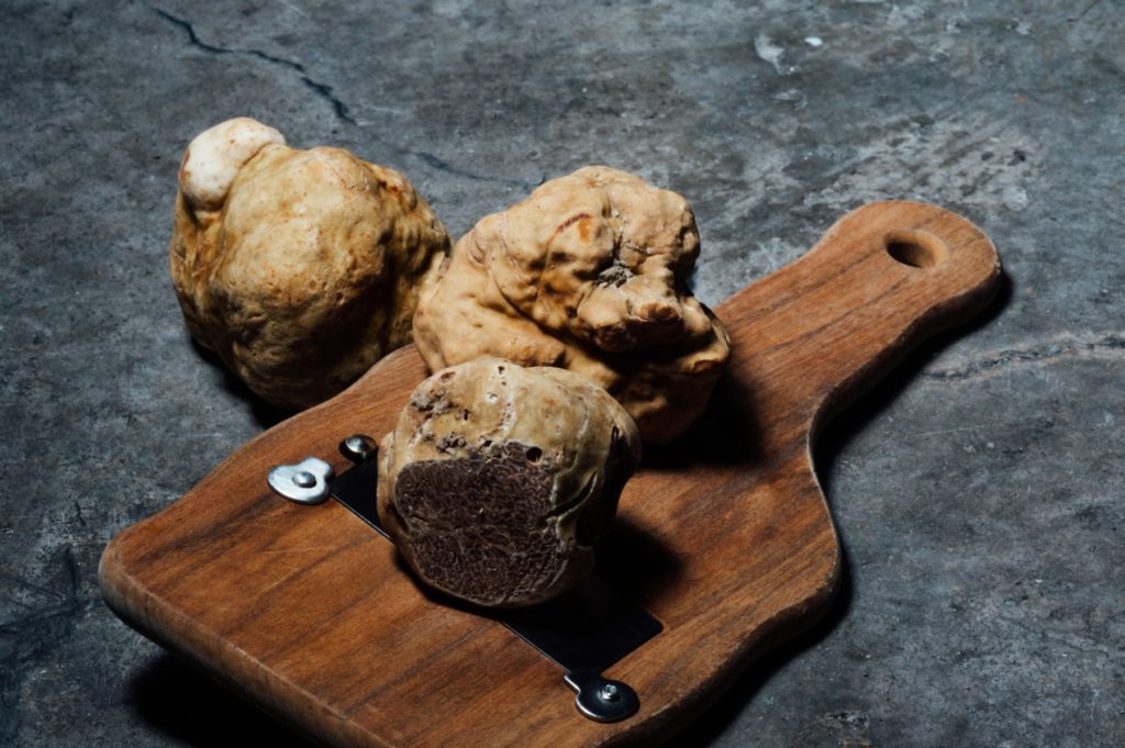 Trois truffes blanches en gros plan, aux textures uniques et à l’arôme intense.